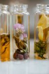 Close-up of assorted dry flowers immersed in glass vials, ideal for natural fragrance products.